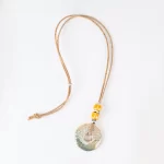 Colar de cortiça com grandes peças redondas de cerâmica e pequenas peçasandrea