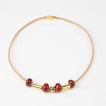 Cork necklace with reddish-orange ceramic and gold terminal