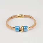 Natural cork bracelet with 2 turns, light blue ceramic tubes and gold beads.